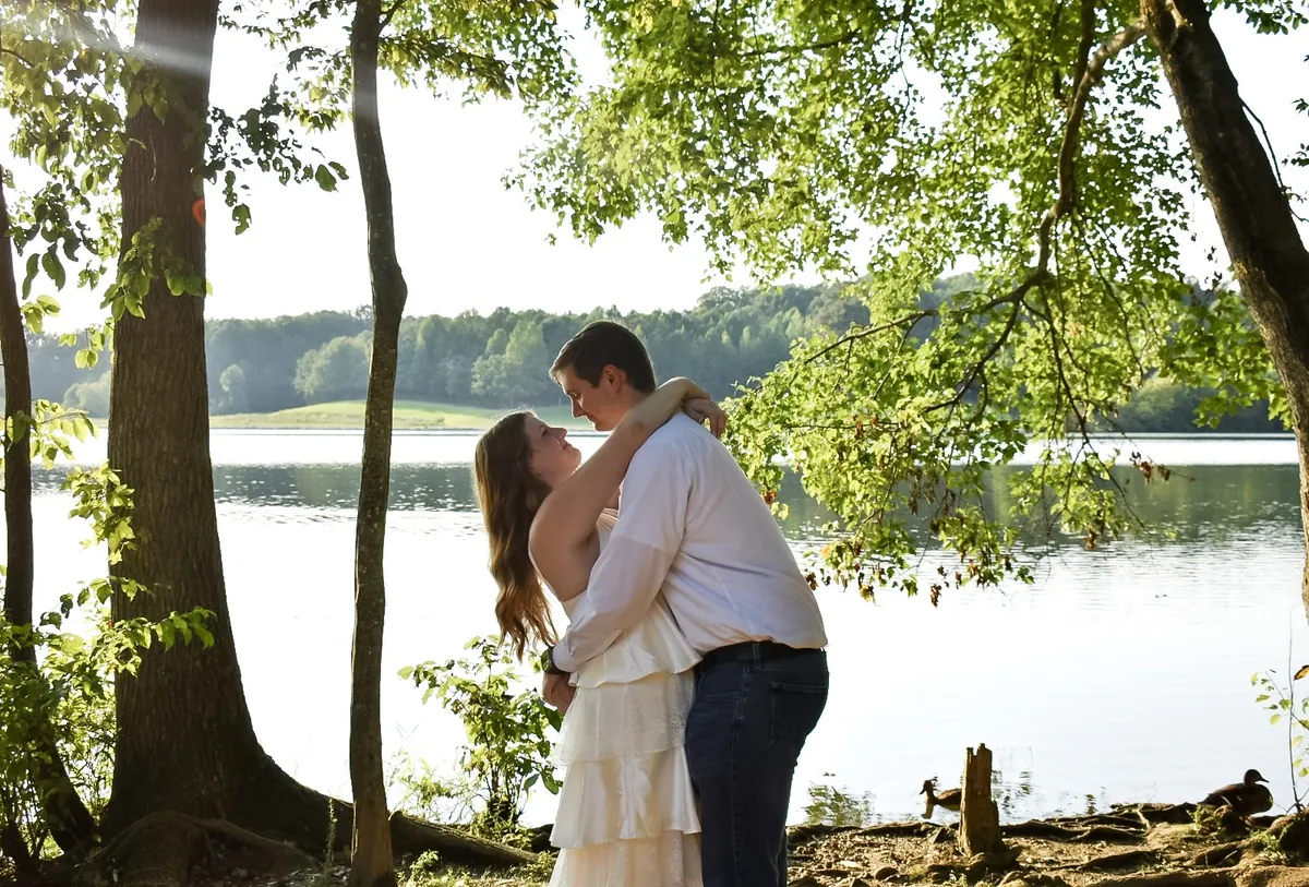 Landon and Alyssa embracing under the trees